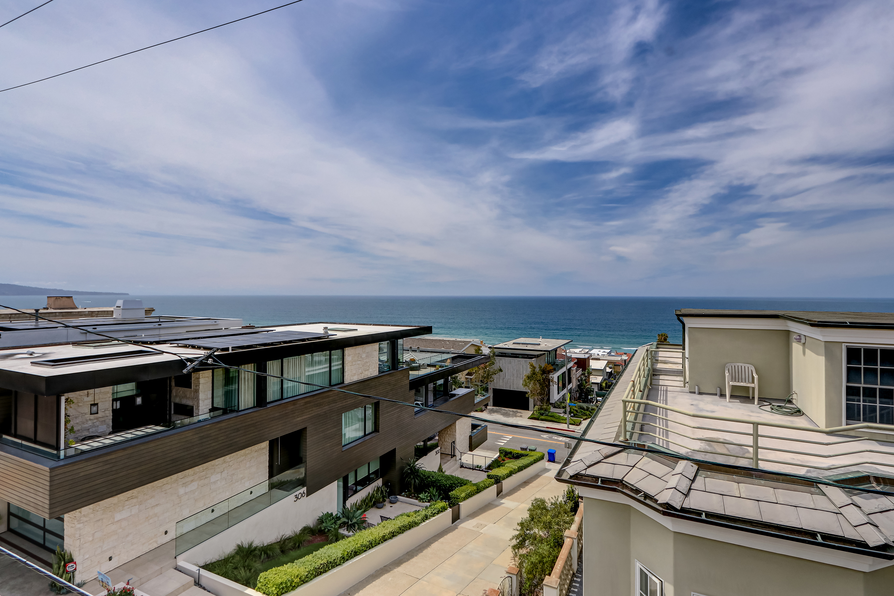 Top-floor balcony with protected ocean view through glass railing and teak ceiling