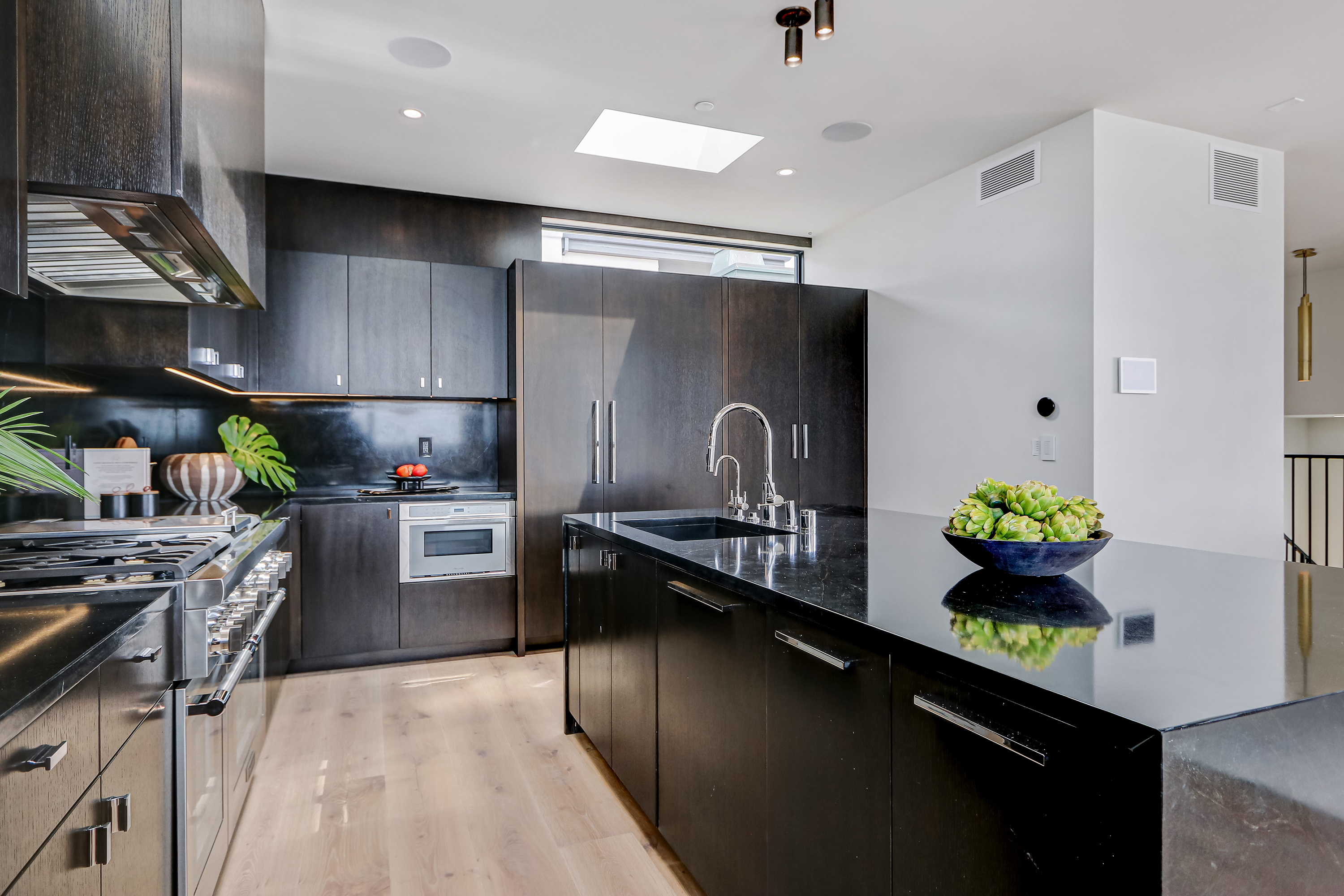 Kitchen with espresso-stained cabinetry, Saratoga soapstone island, and natural oak floors