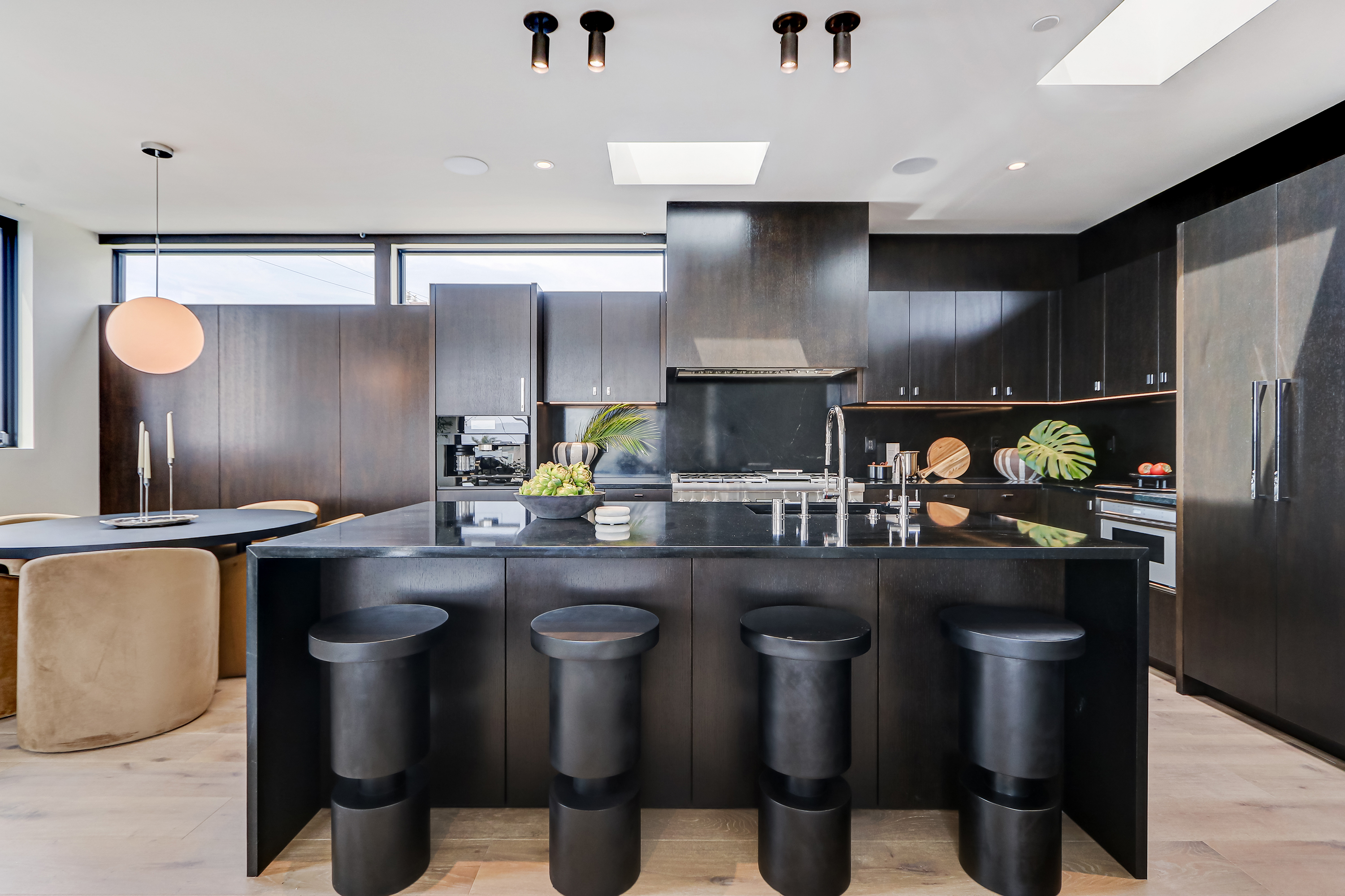 Detail of espresso millwork with monstera plant and integrated appliance