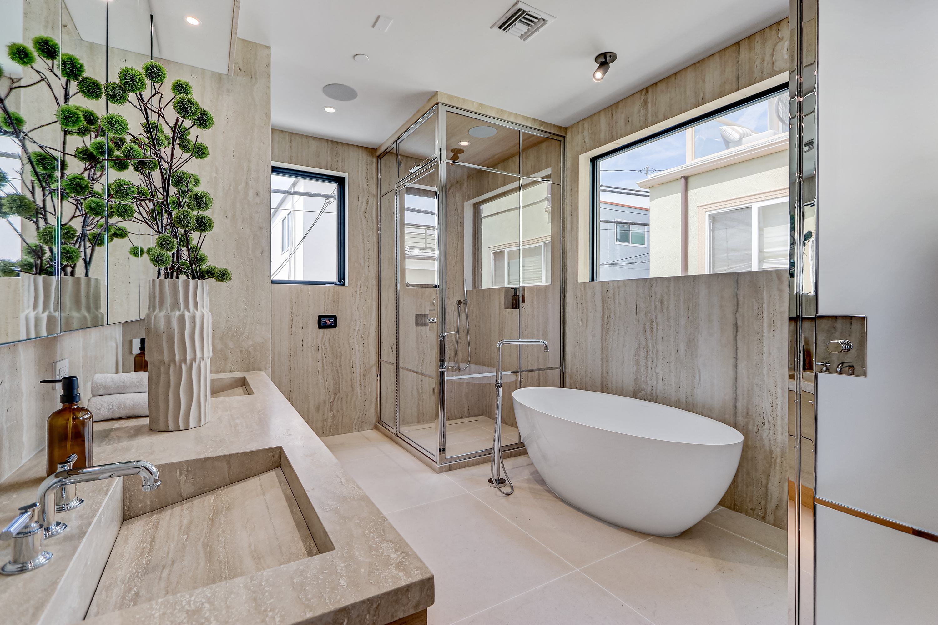 Bathroom finished in Calacatta marble with custom mirror and silver sconces